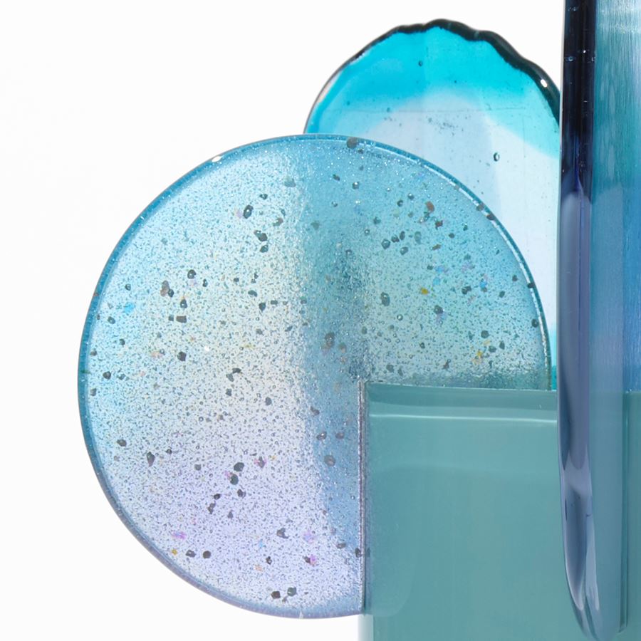 opaque teal cylinder with five rounded finials overlapping and perched on the top rim with abstract patterns in blue aqua jade turquoise lilac grey and yellow hand made from blown and fused glass